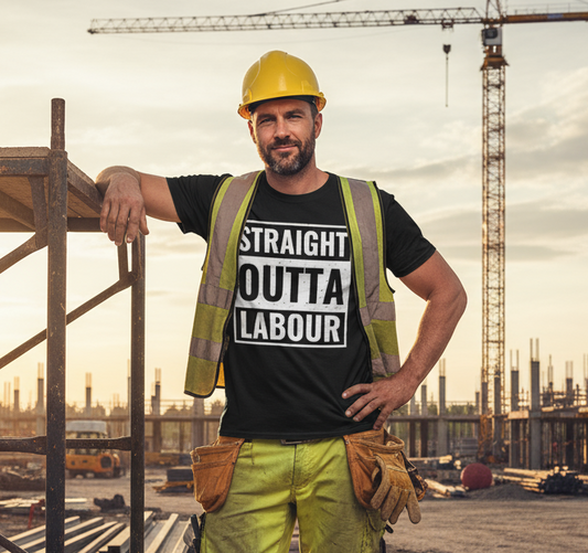 Construction worker in high-visibility gear and hard hat standing on a construction site with cranes and buildings in the background.