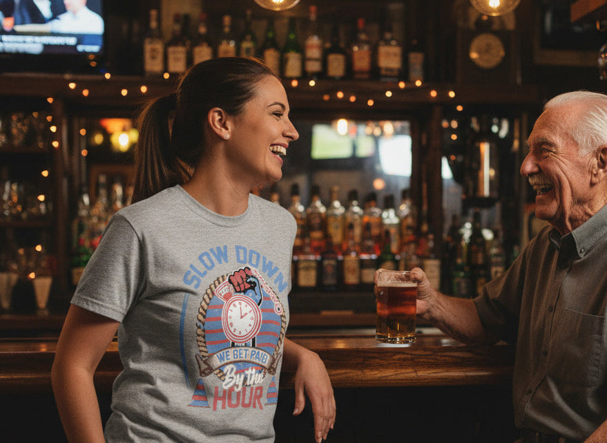 Woman in a bar wearing a 'Slow Down Hour' t-shirt interacting with an older man.